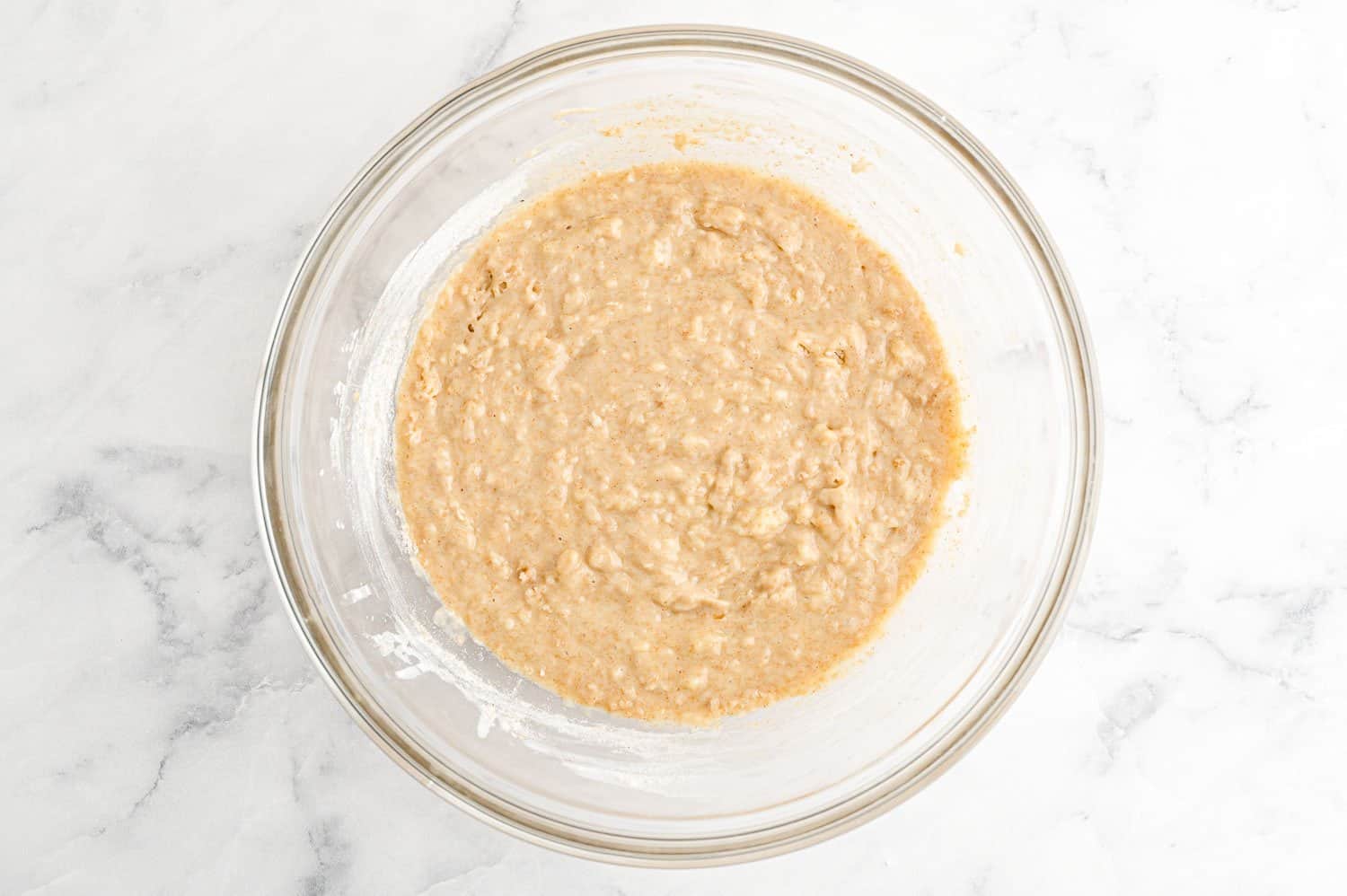 Muffin batter in a clear glass bowl.