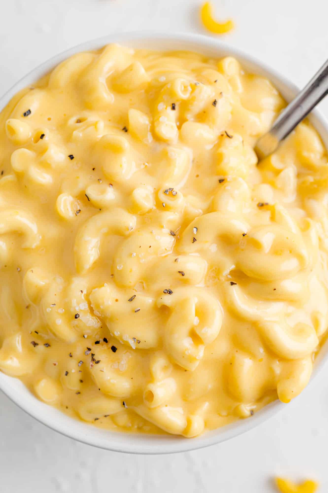 Crockpot macaroni and cheese with a spoon.