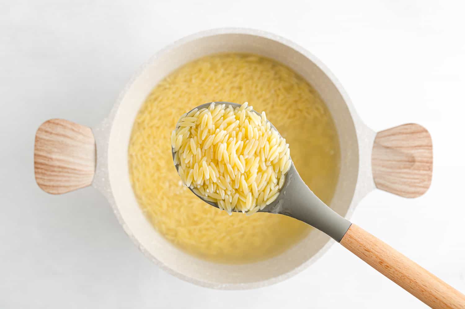 Coked pasta on a spoon and in a pot.