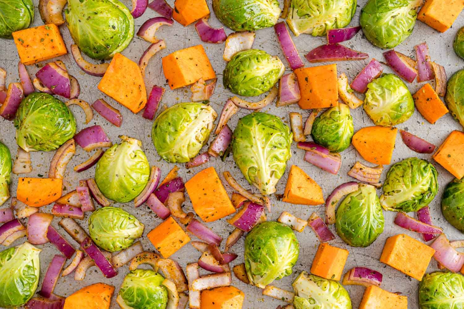 Uncooked vegetables arranged on a sheet pan.