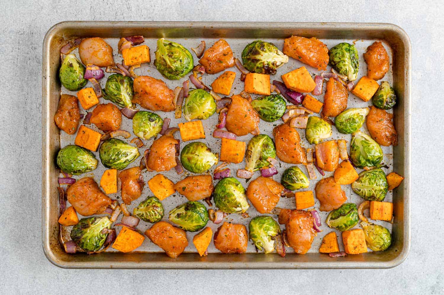 Vegetables and chicken on a sheet pan.