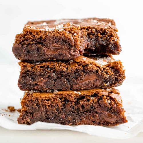 Stack of three fudgy kahlua brownies on a white background.