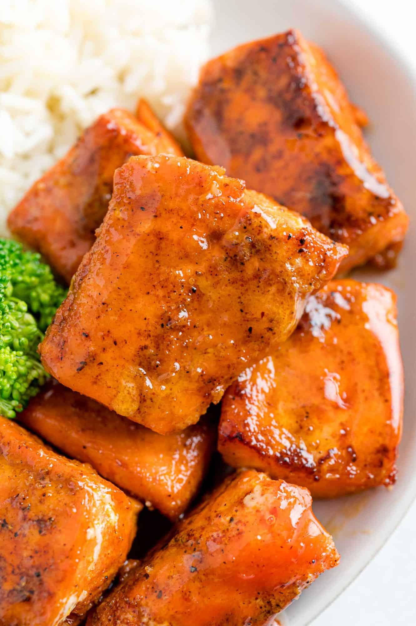 Salmon bites on a plate with broccoli and rice.