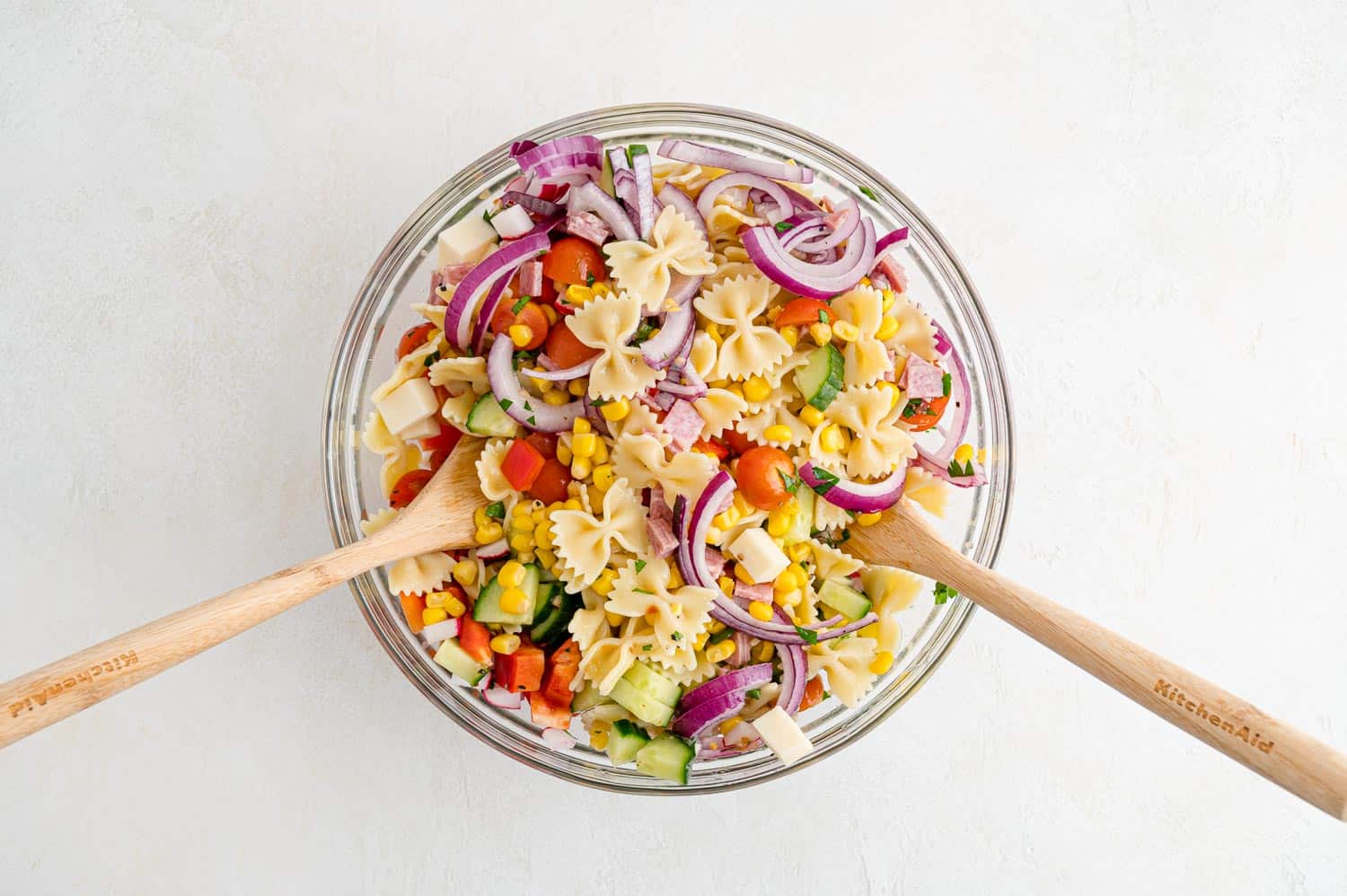 Pasta salad being stirred.