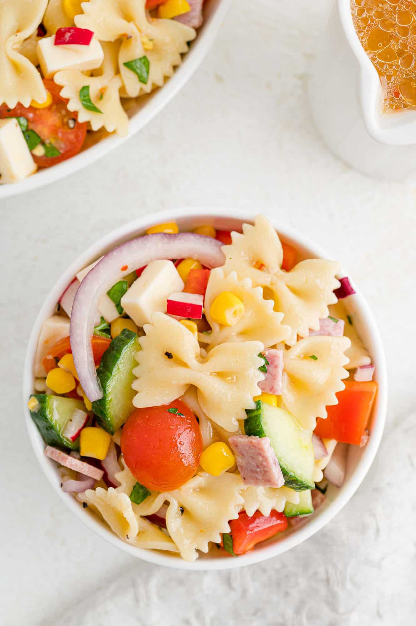 Pasta salad in a small round white bowl.