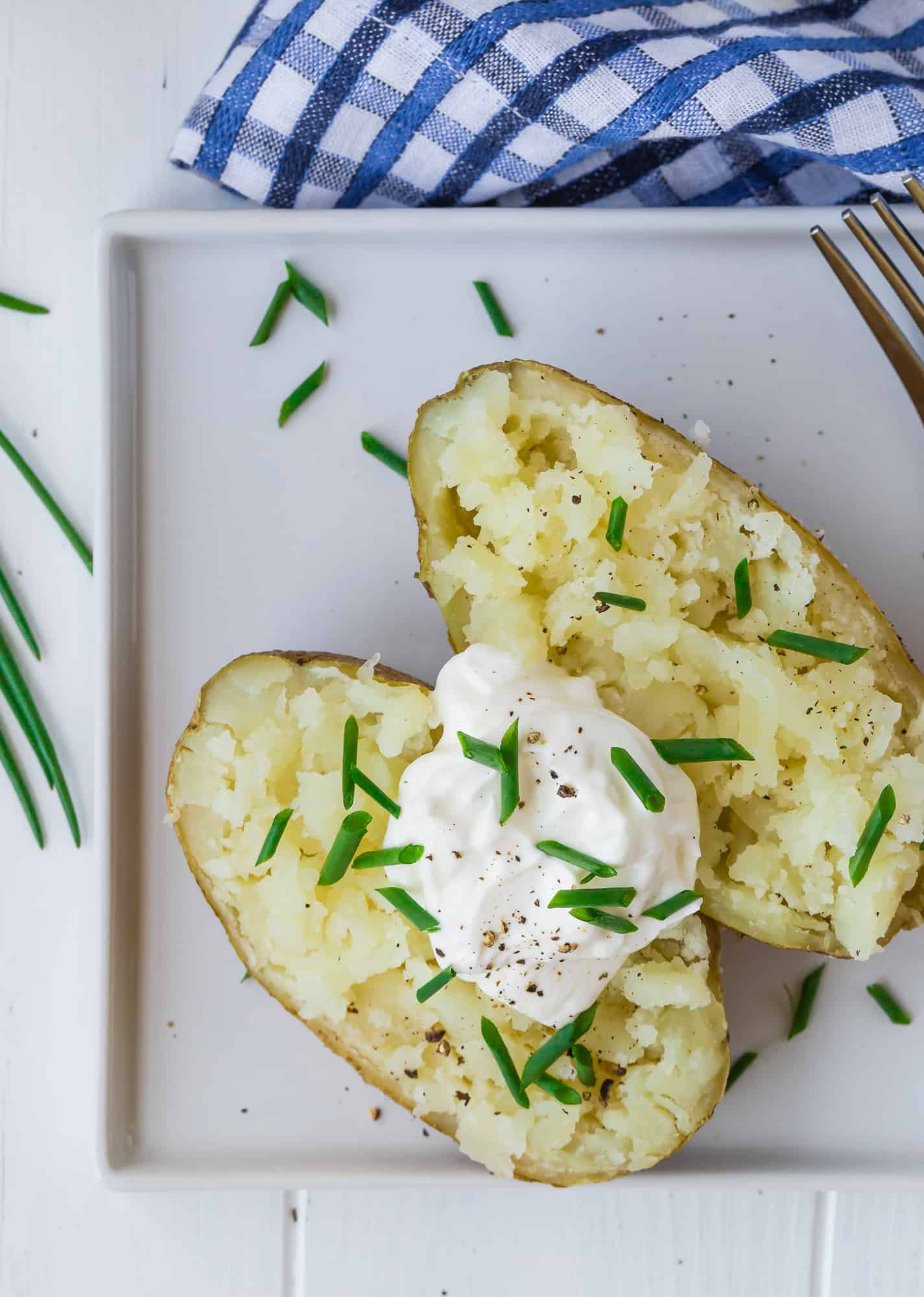 White plate with a baked potato on it.