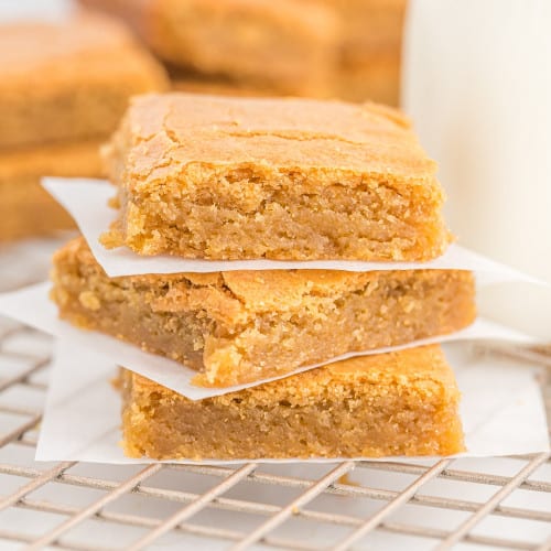 Blondies stacked three high with parchment between layers.