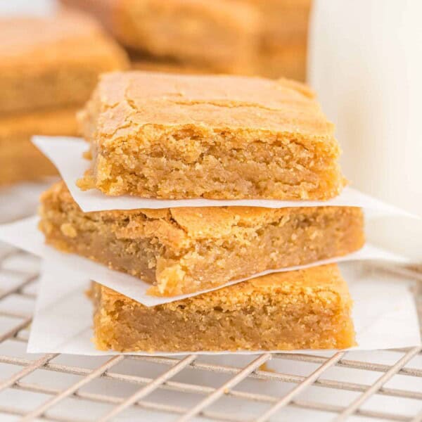 Blondies stacked three high with parchment between layers.