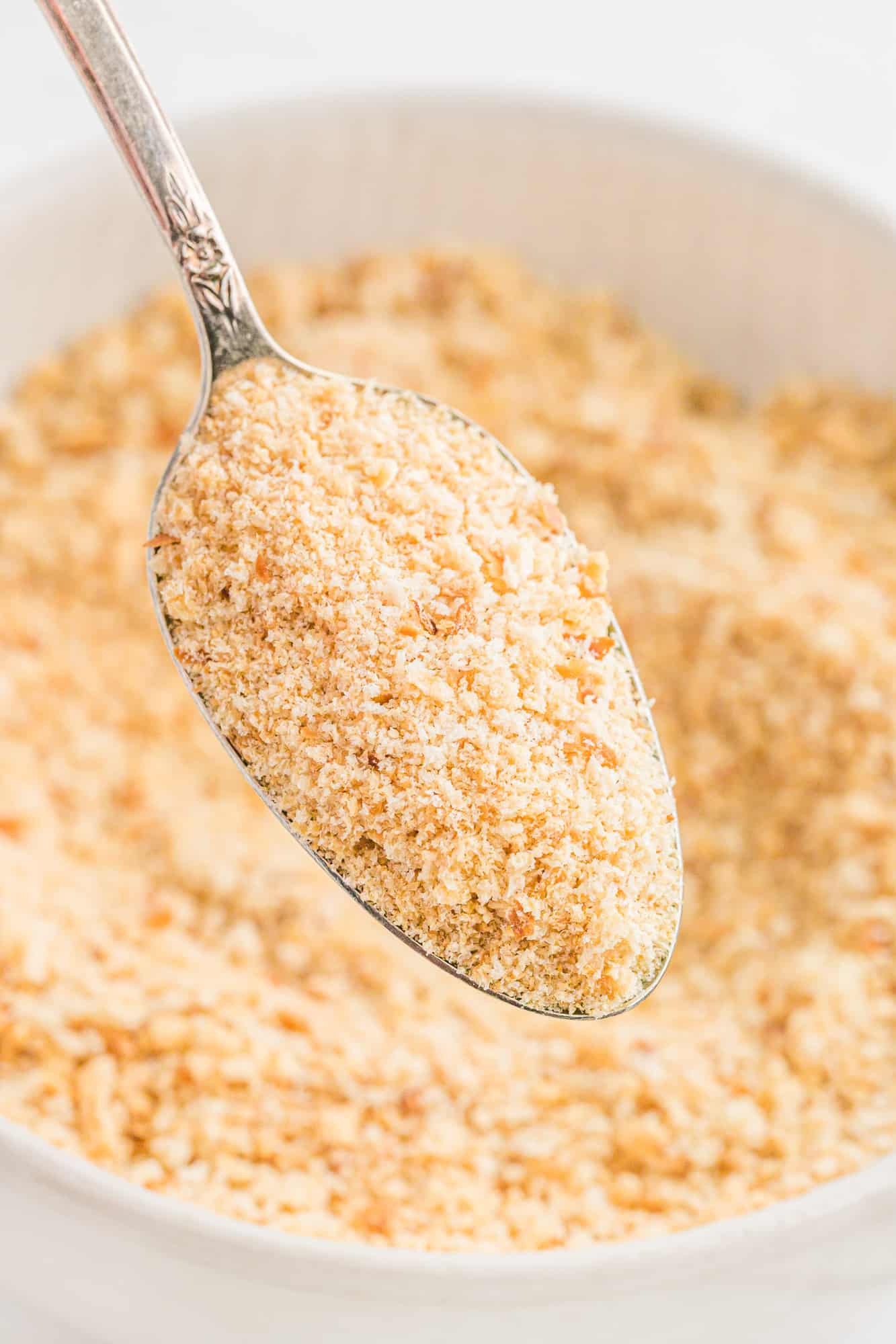 Homemade Bread crumbs on a spoon over a bowl.