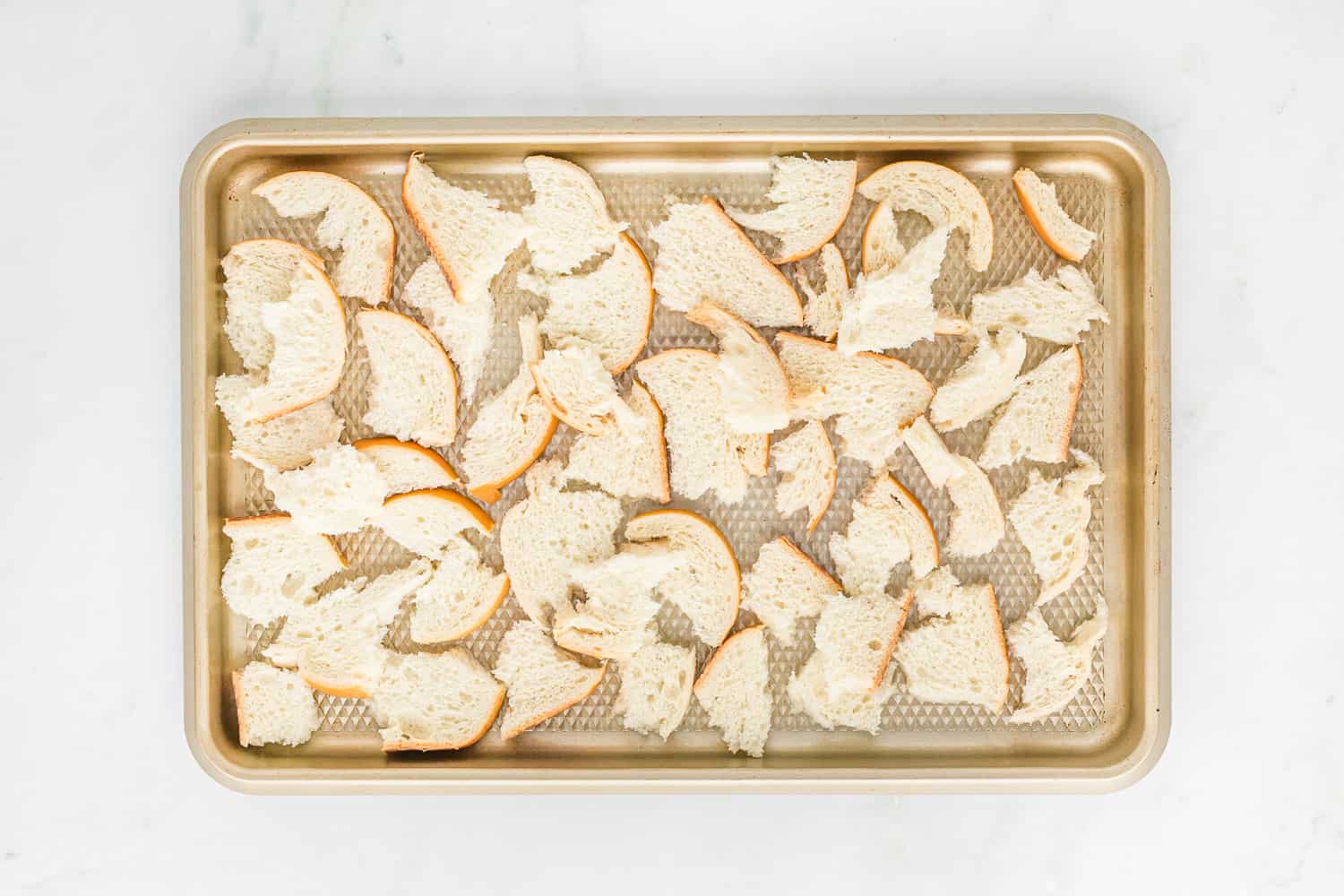 Torn bread on a baking sheet.