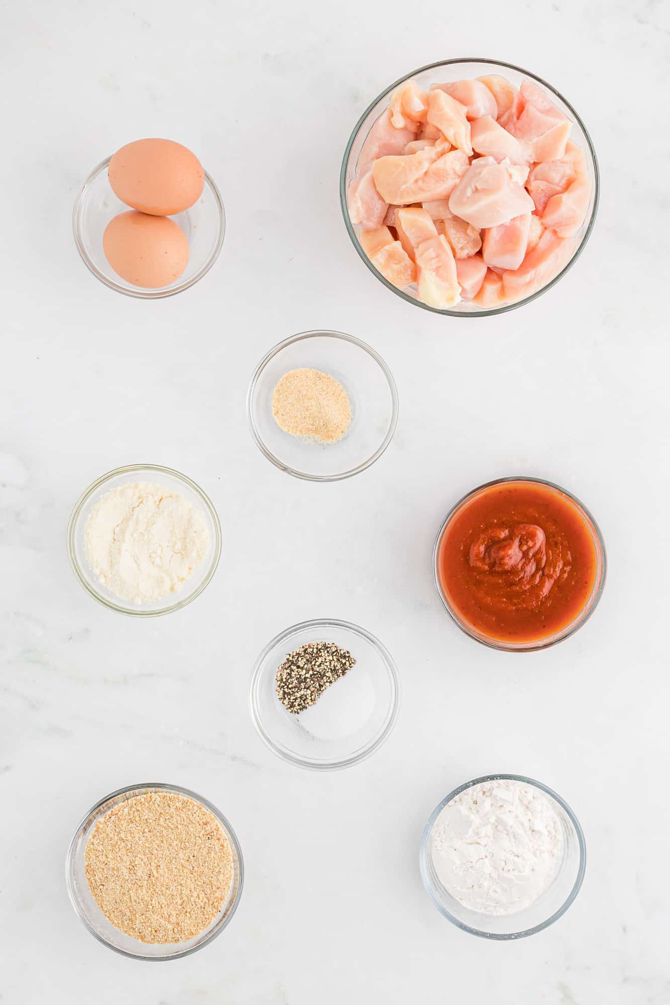 Overhead view of ingredients in separate bowls, including chicken.