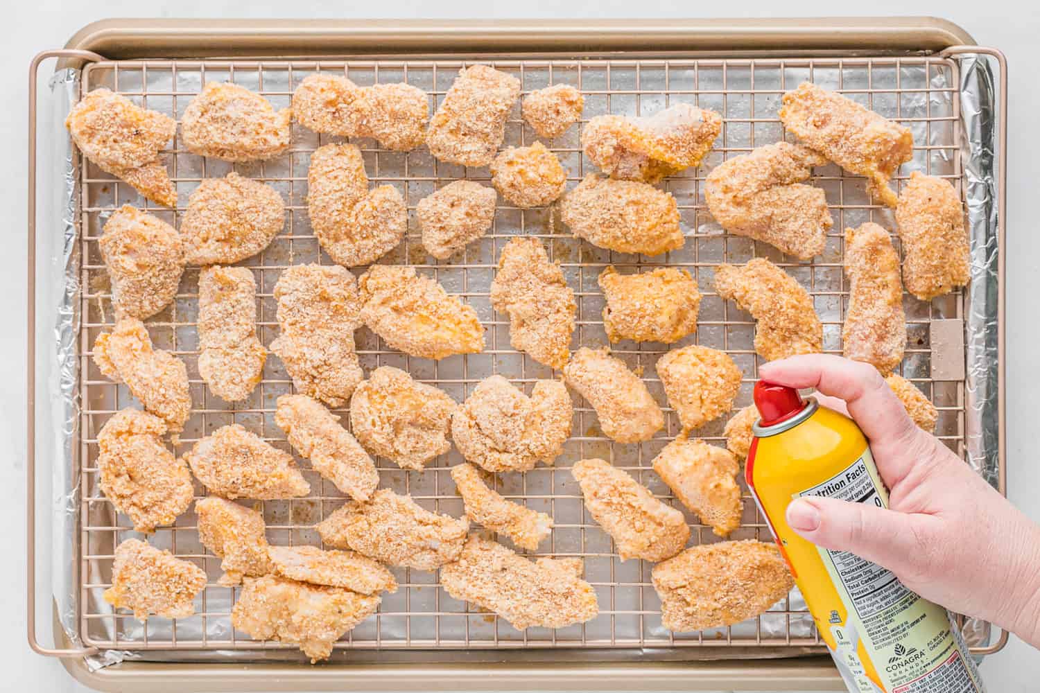Unbaked chicken nuggets on baking rack.