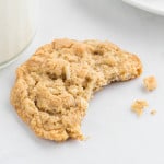 Crispy coconut oatmeal cookie with a bite taken out of it.