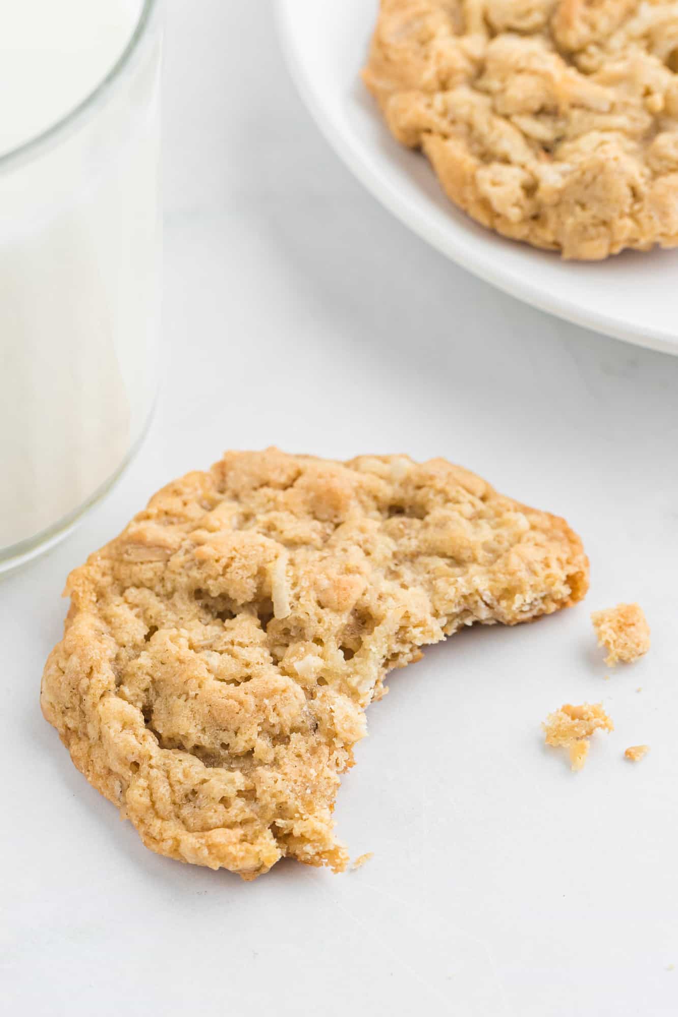 Crispy coconut oatmeal cookie with a bite taken out of it.