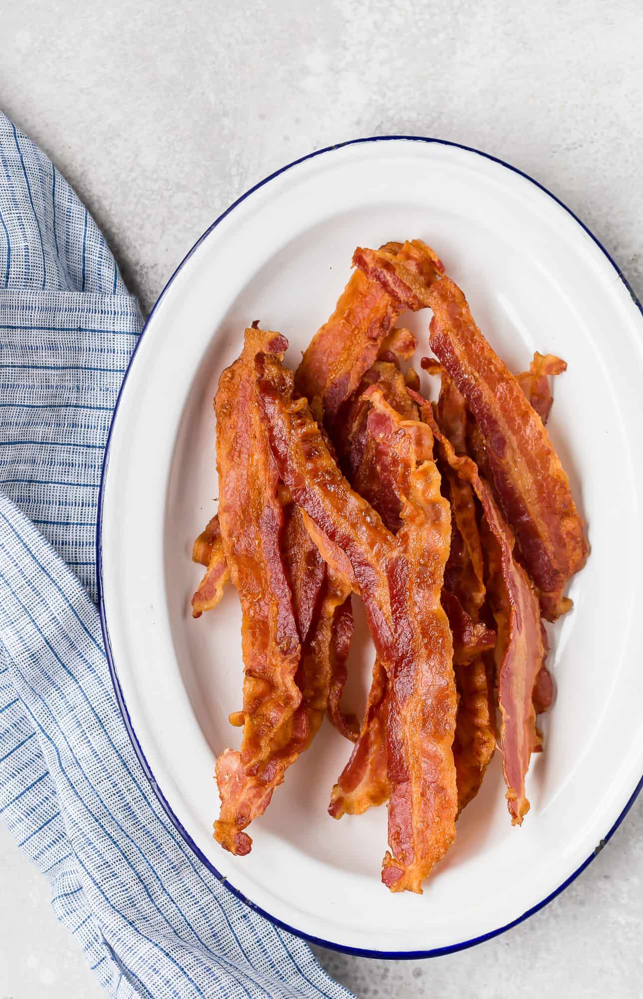White and blue plate filled with bacon.