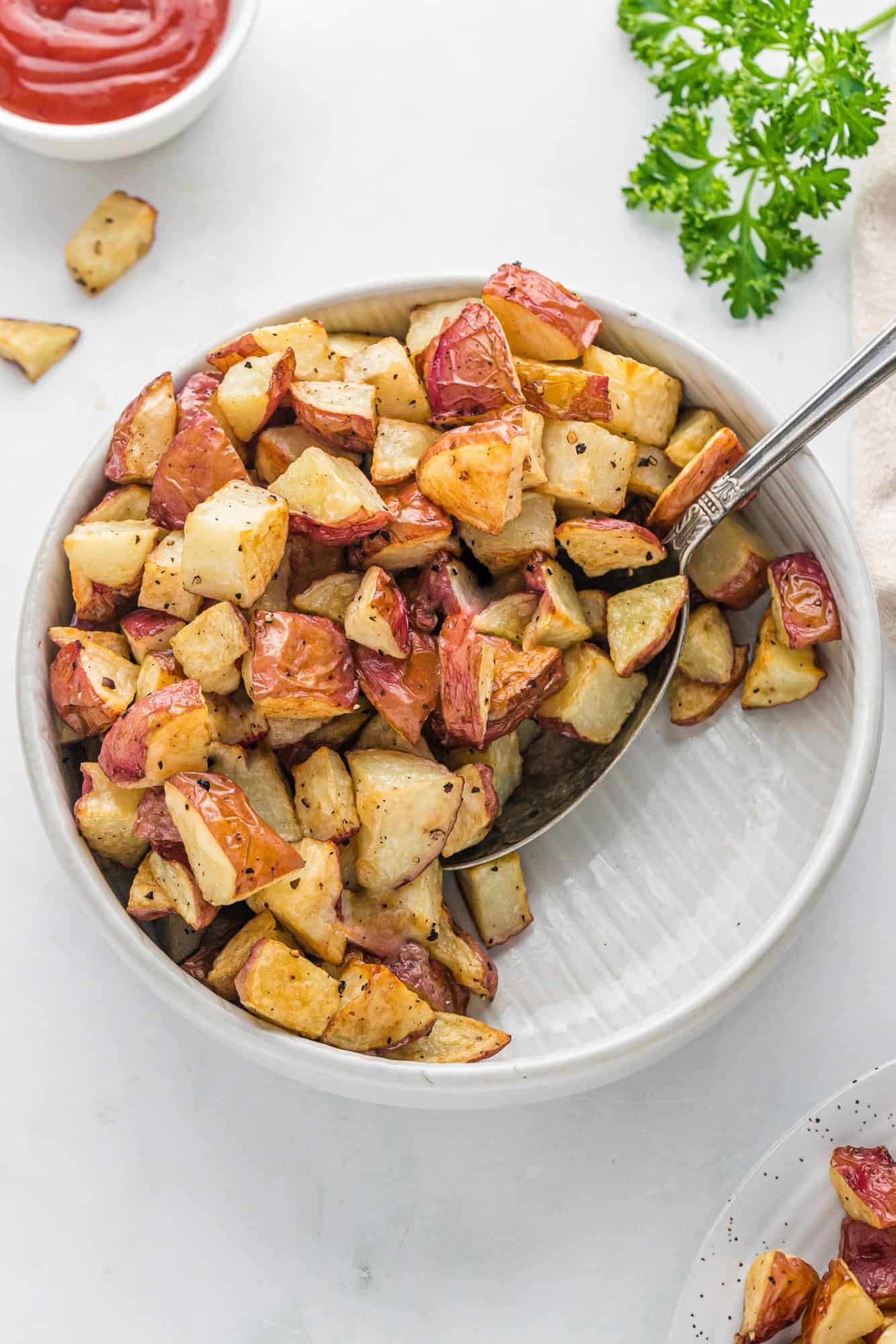 Cooked potatoes in large white serving bowl.