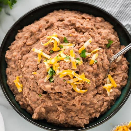 Crockpot refried beans in a large black bowl.