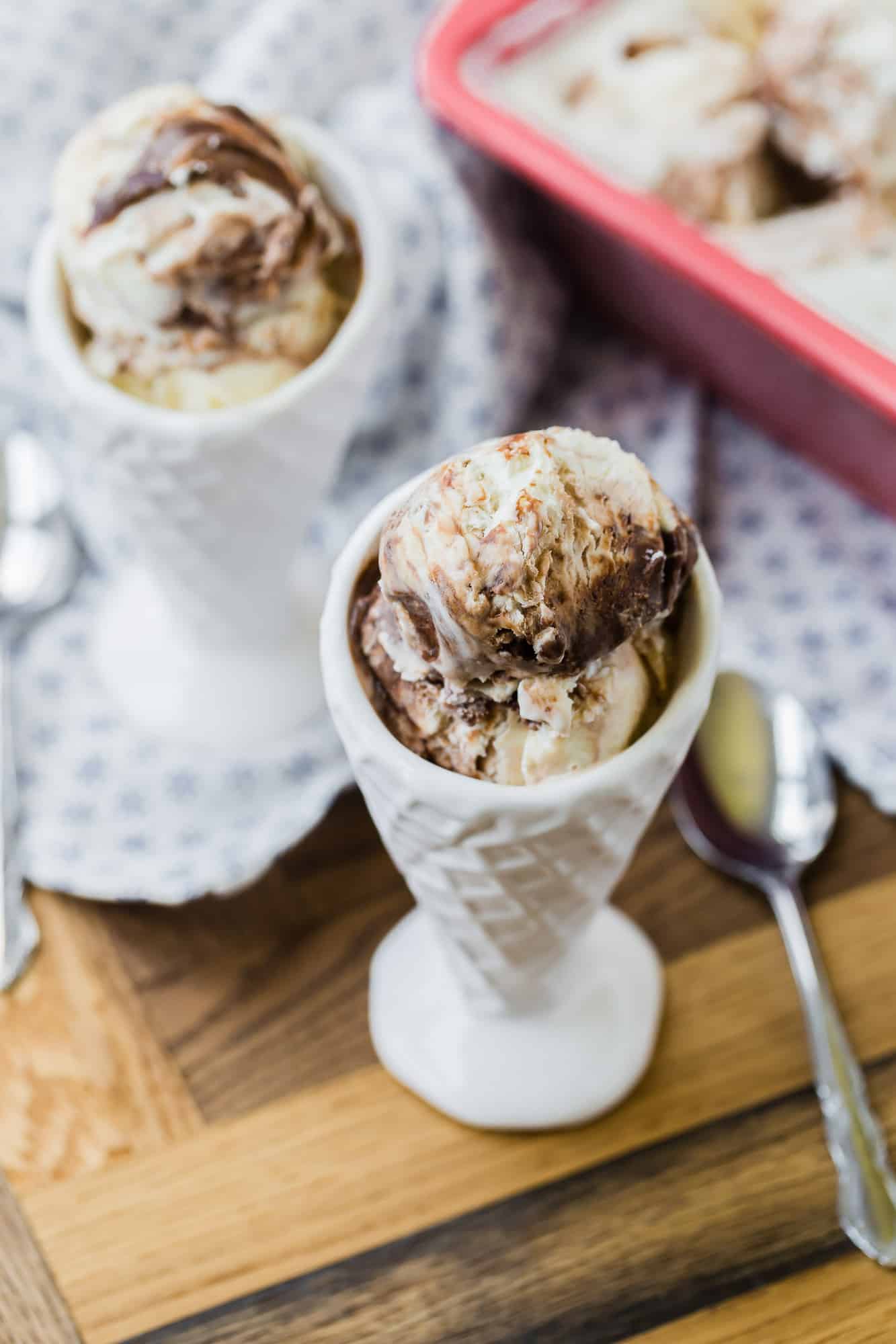 Ice cream in a white cone shaped bowl.