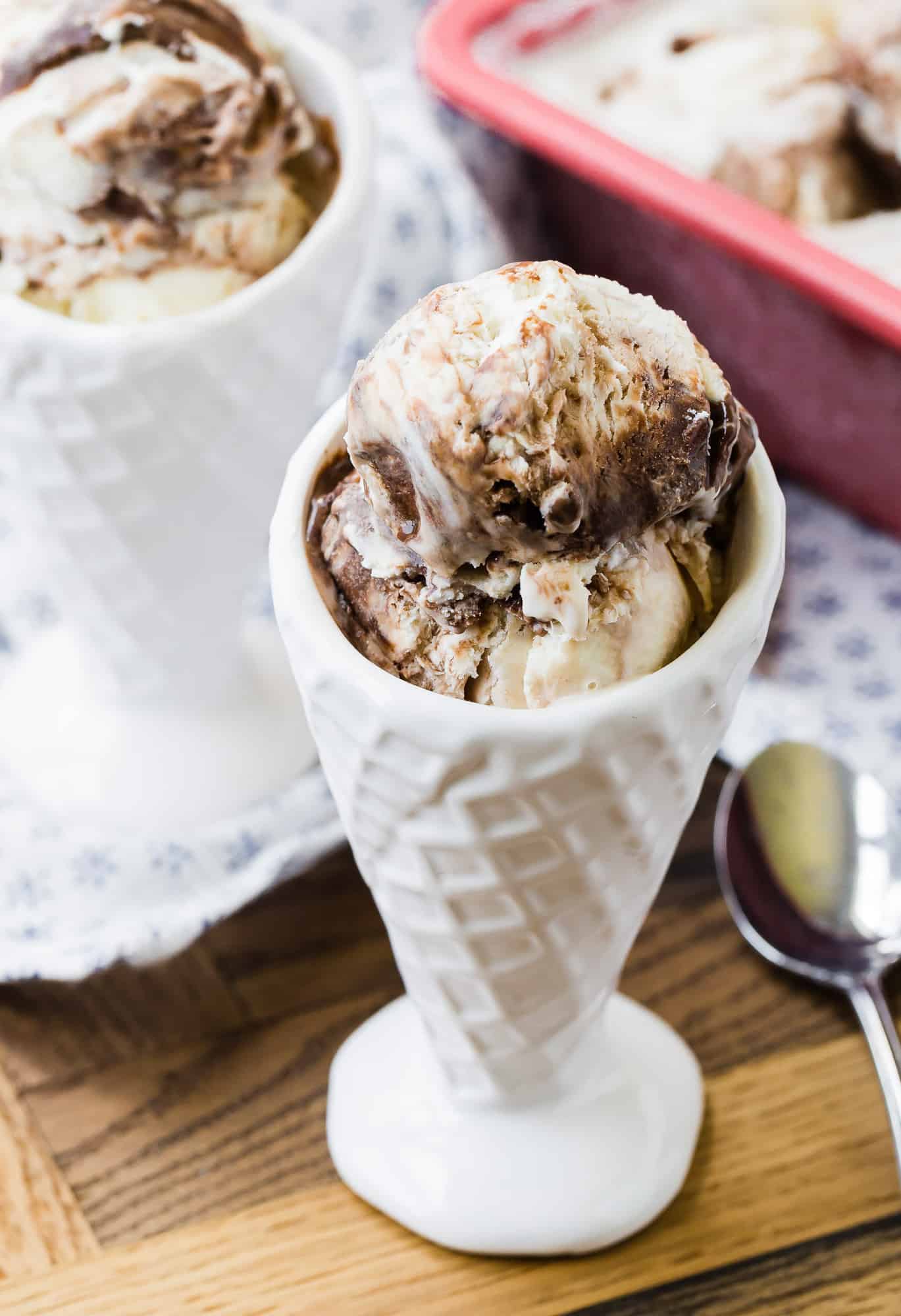 Fudge swirl ice cream in a cone shaped cup.