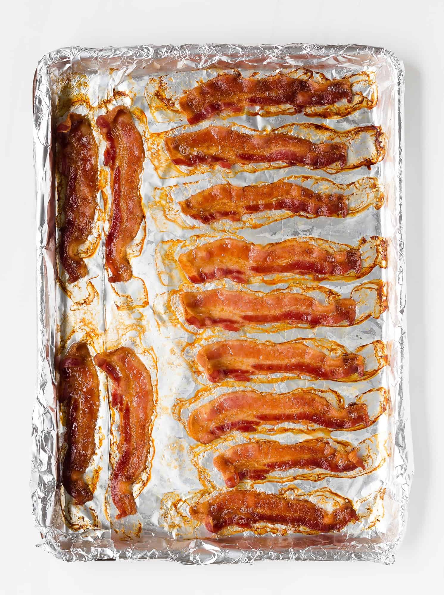 Cooked bacon on a foil lined baking sheet.