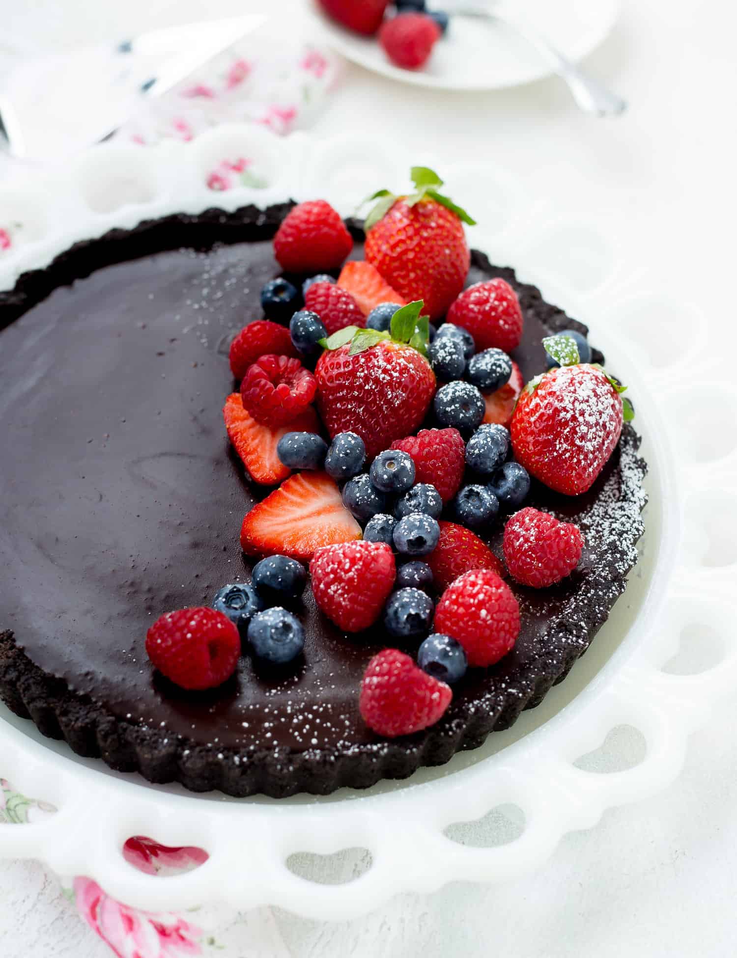 Chocolate tart topped with fresh berries and powdered sugar.