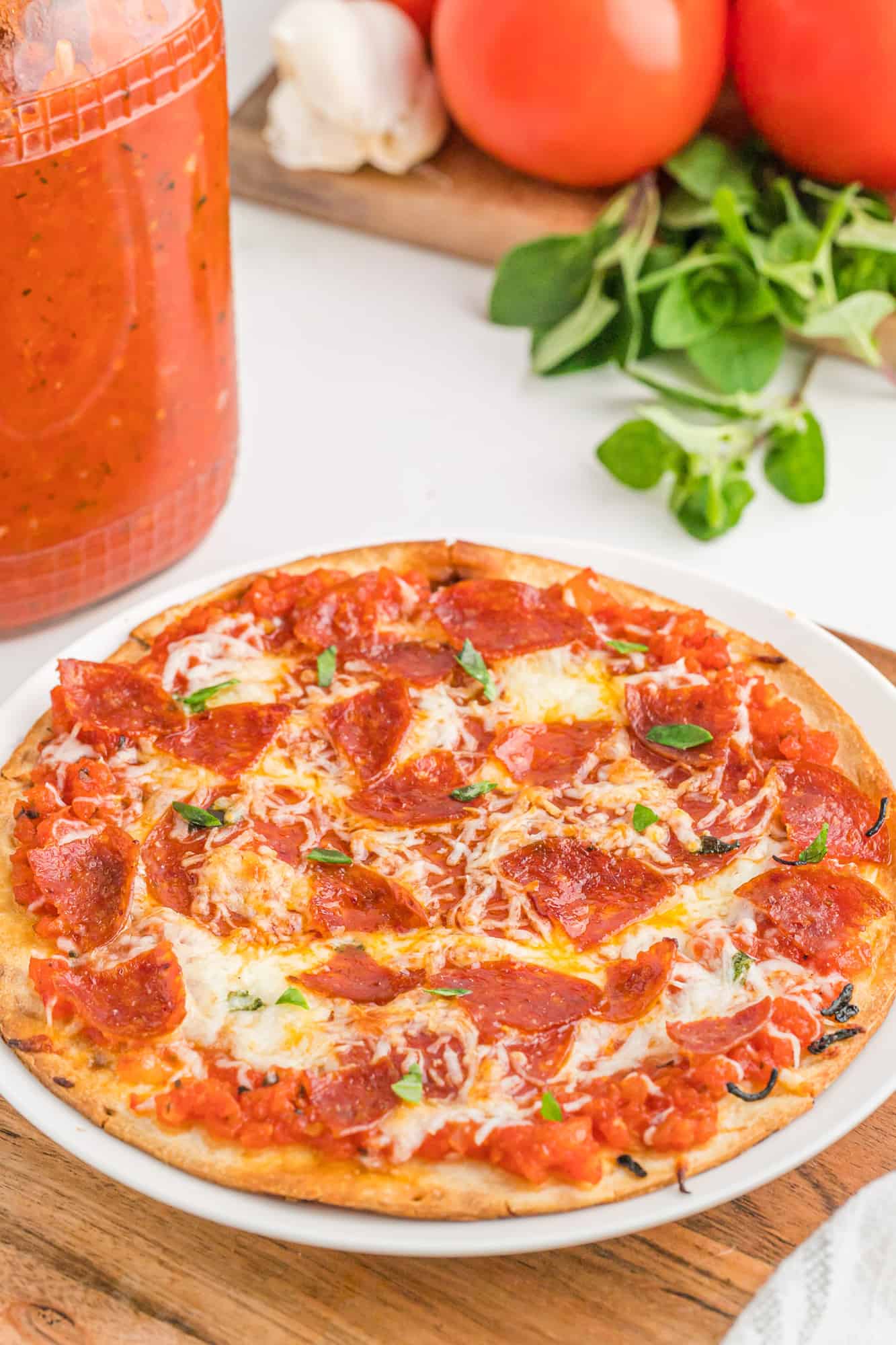 Pepperoni pizza with homemade sauce in background.