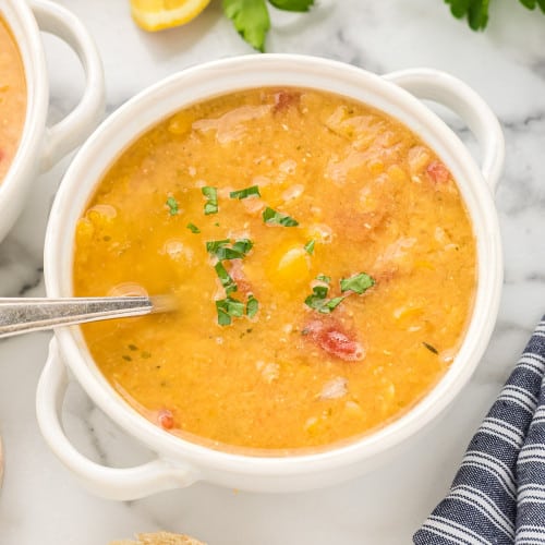 Red lentil soup in a white bowl.