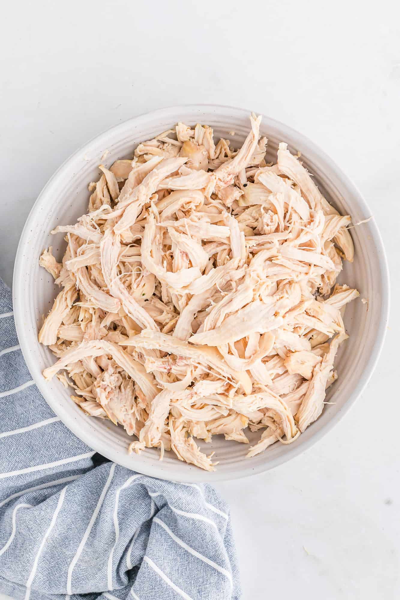 Shredded chicken in a white bowl.