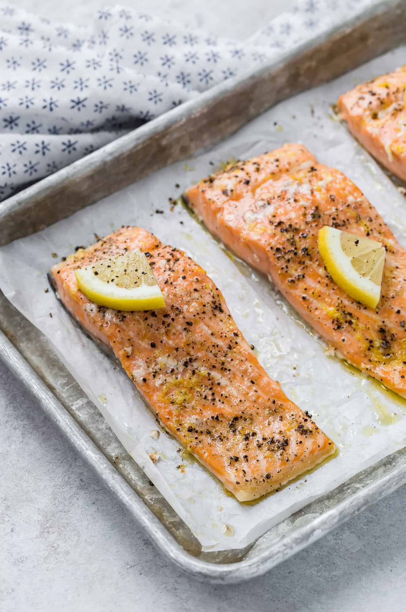 Slow roasted salmon on a parchment paper lined baking sheet.