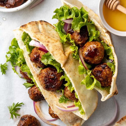 Chipotle glazed meatballs in two pita halves with lettuce.