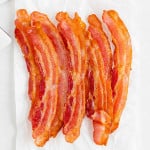 Crispy air fryer bacon on a white background.