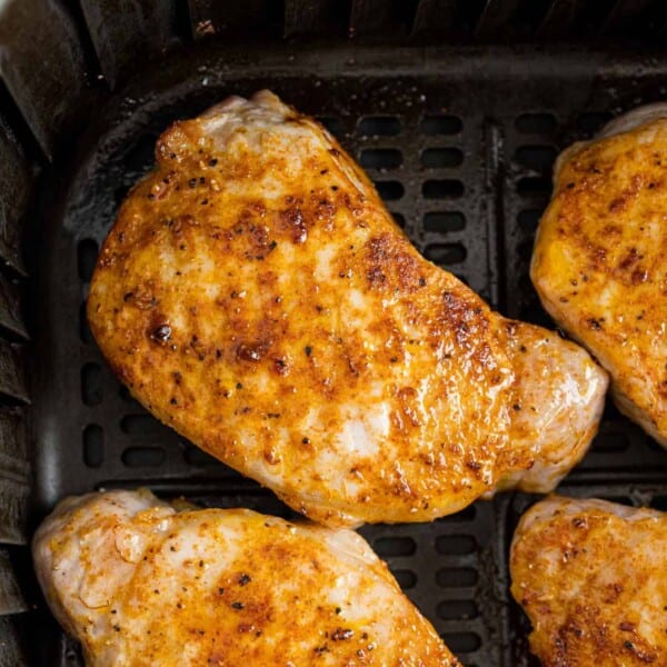 Air fryer pork chops in the basket of an air fryer.