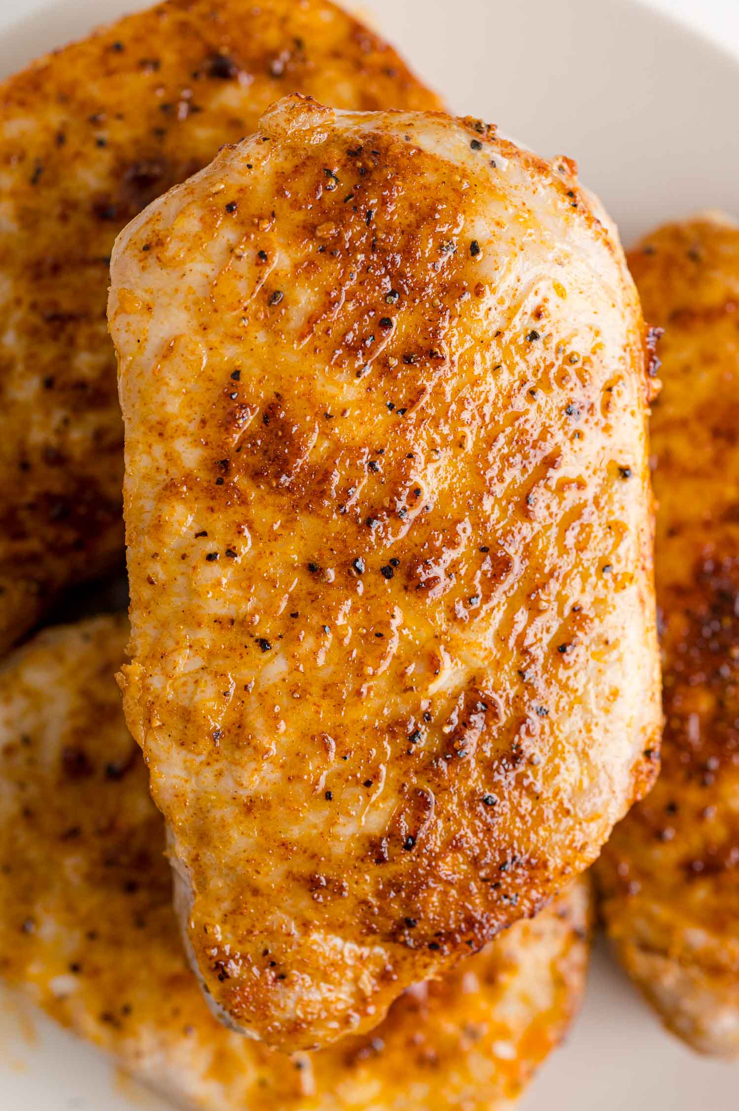 Seasoned pork chop on a plate with others.