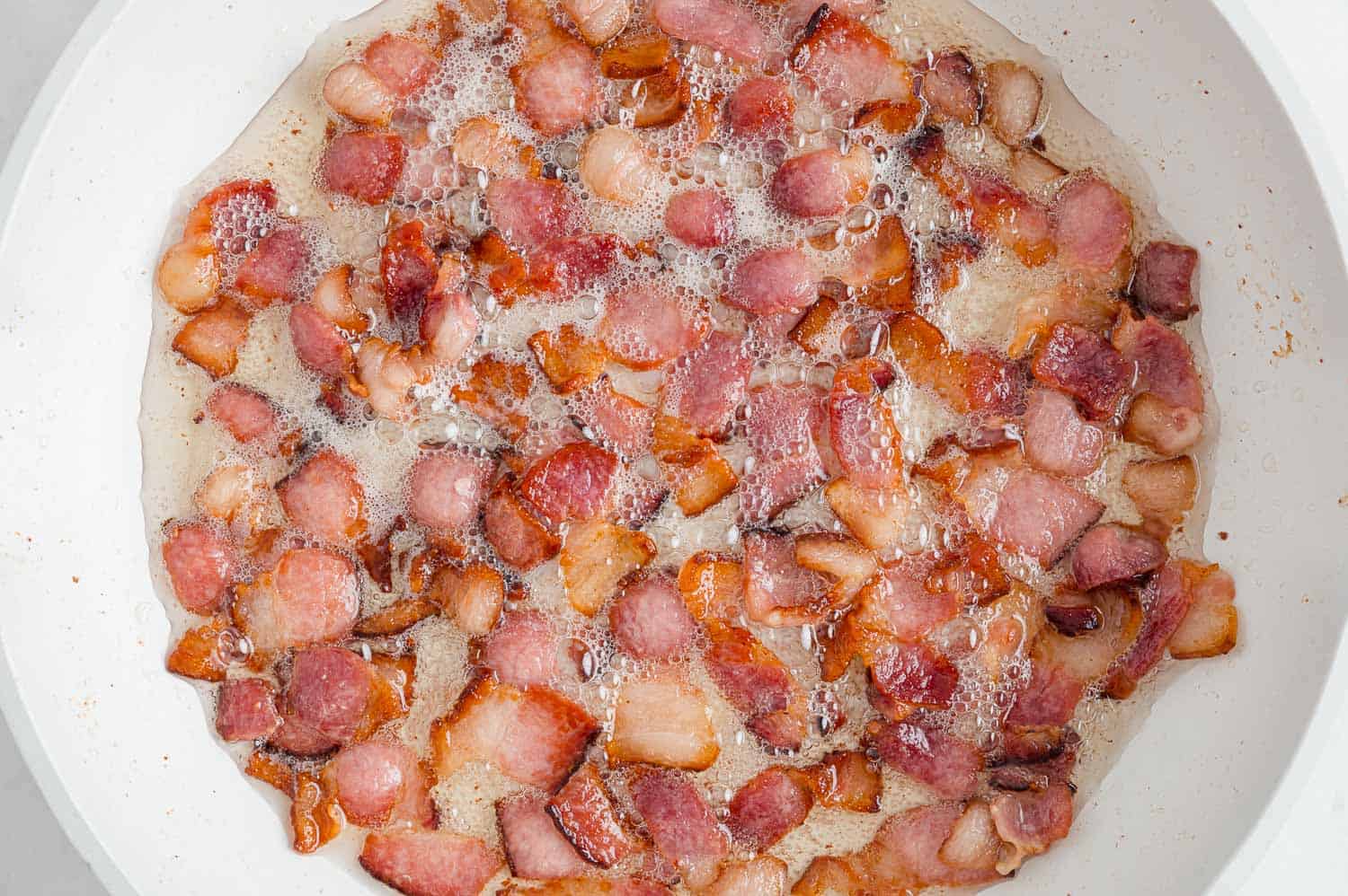 Bacon cooking in frying pan.