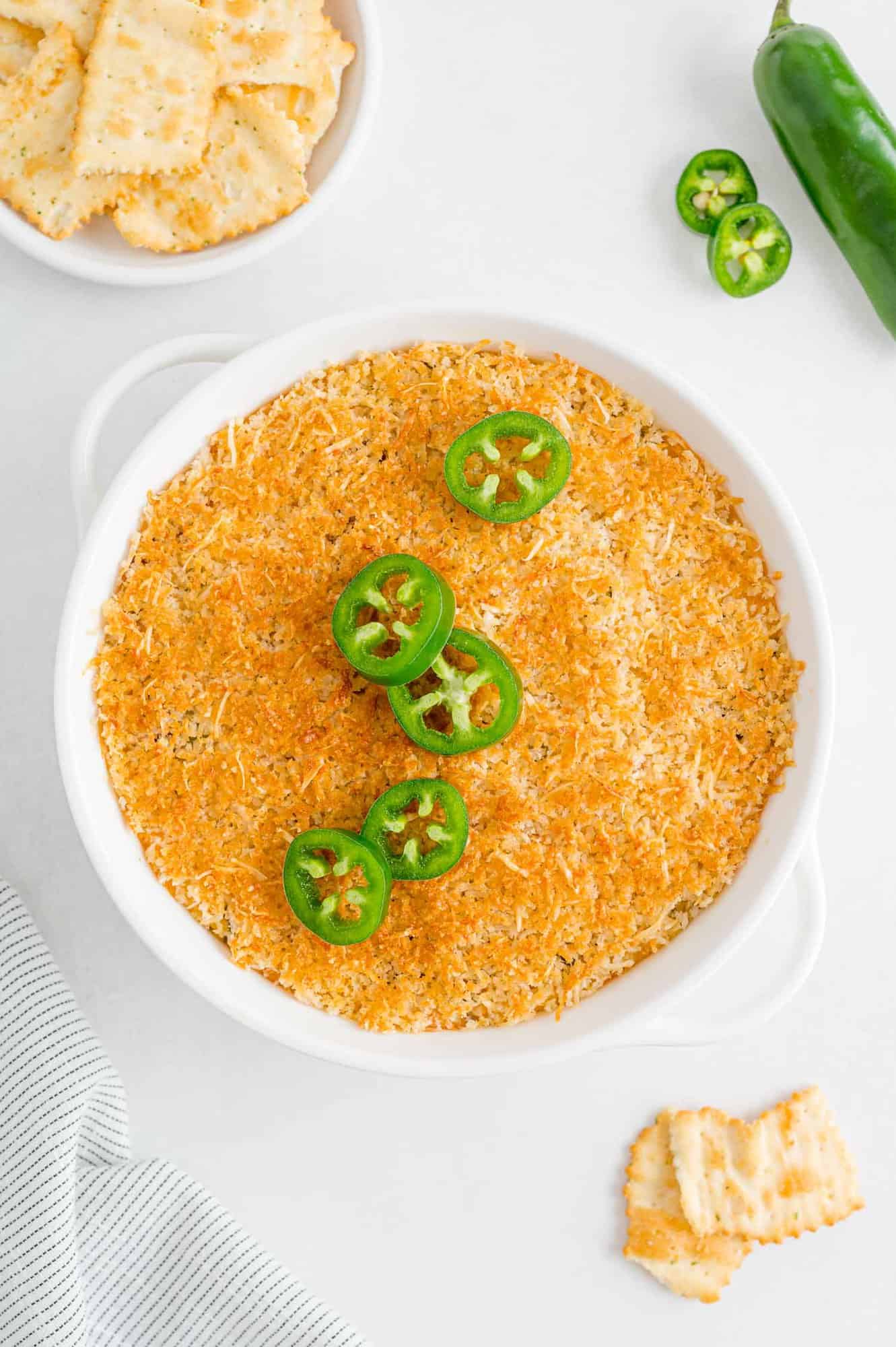 Baked dip topped with sliced jalapeño peppers.