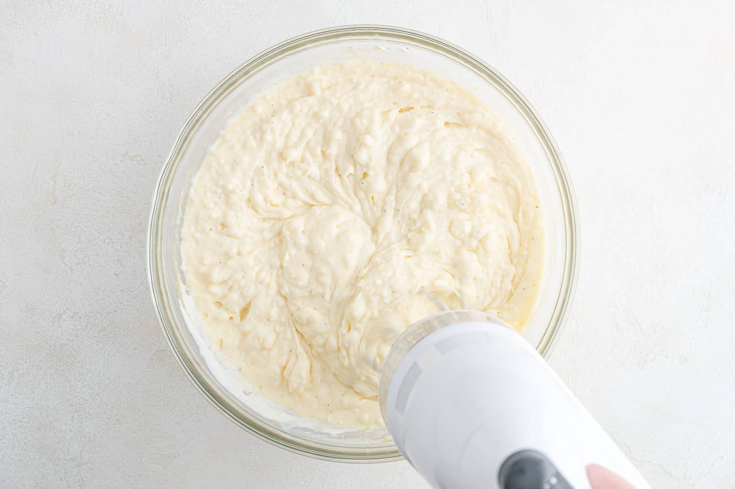 Ingredients being mixed with a hand mixer.