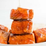 A stack of salmon bites being drizzled with hot honey.