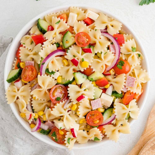 Summer pasta salad in a round white bowl.