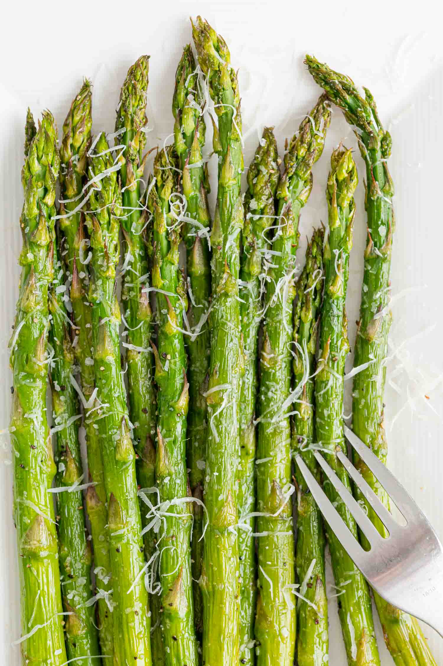 Asparagus with cheese and a fork.