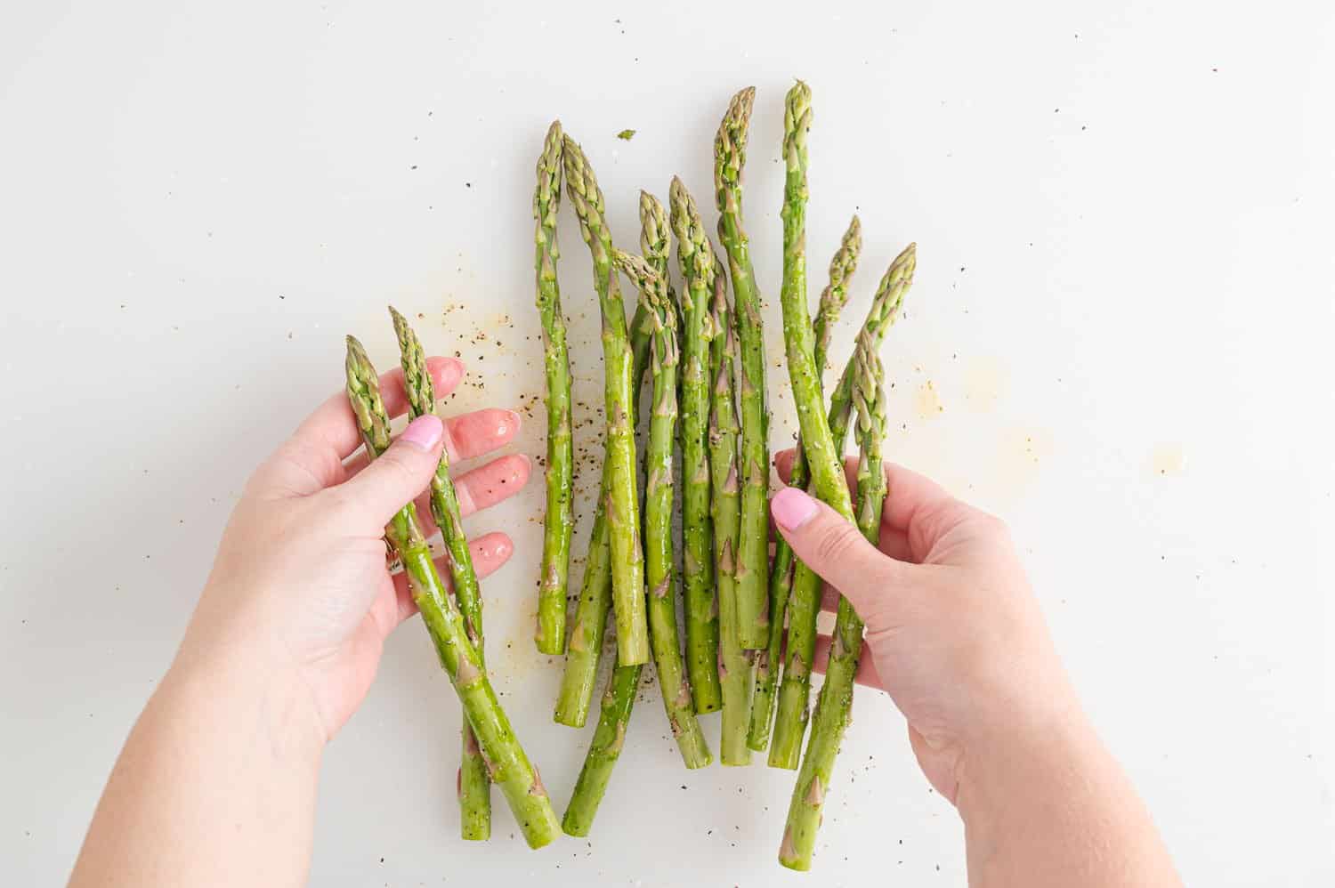 Asparagus being tossed with seasoning.