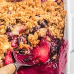 Apple blueberry crisp with some scooped out to show filling.
