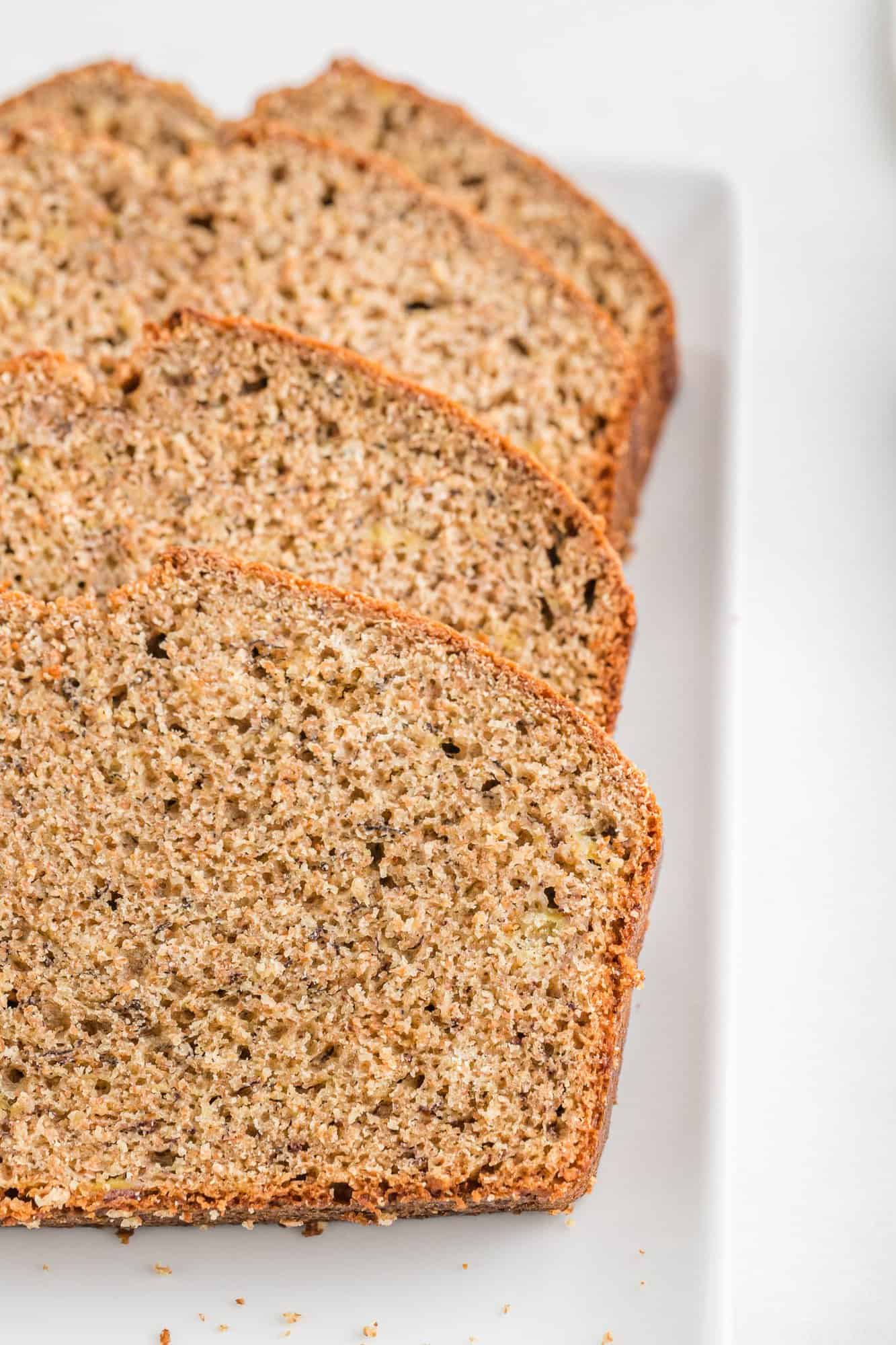 Three slices of whole wheat banana bread on a platter.