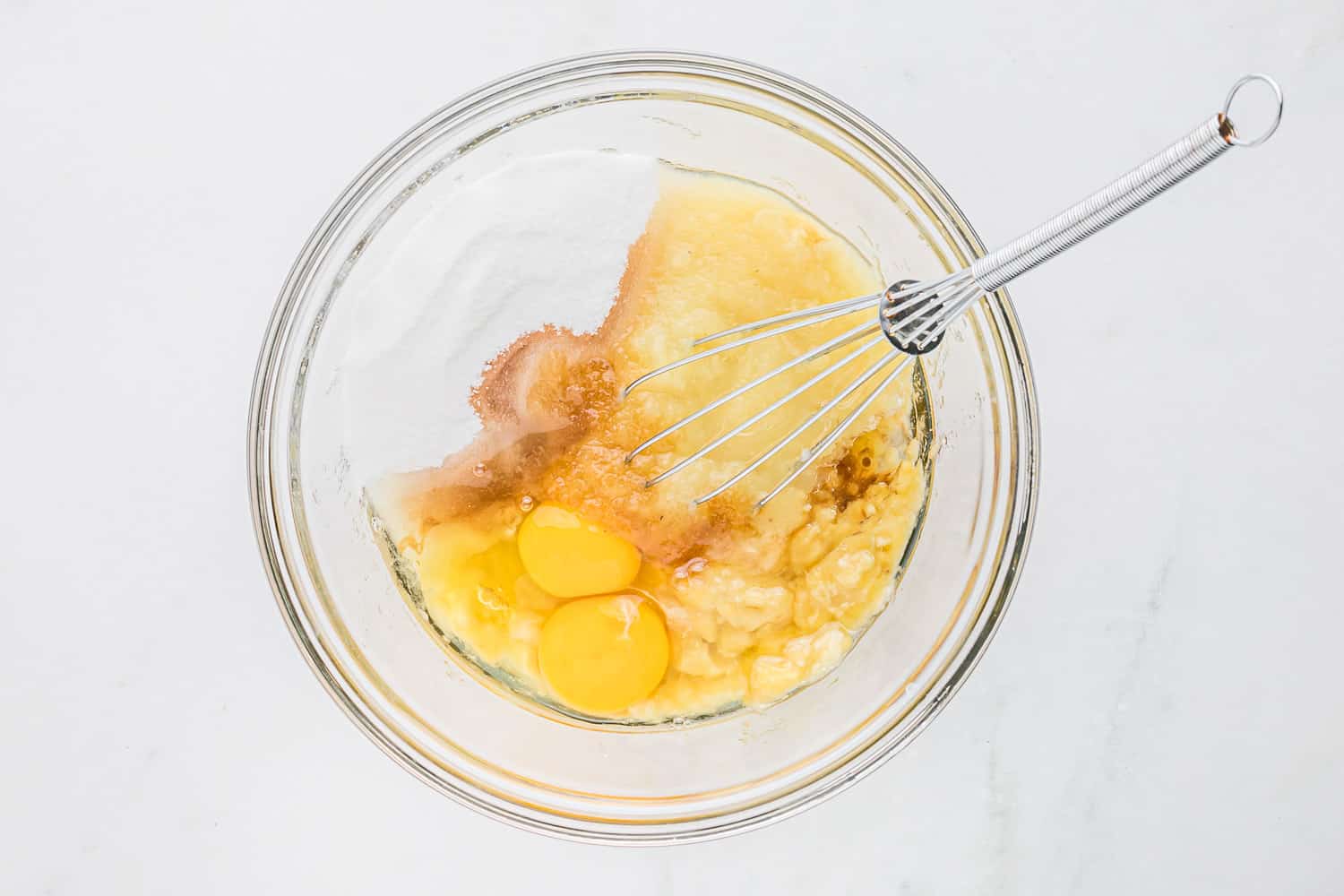 Wet ingredients in clear glass mixing bowl.