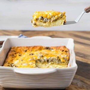 9x13 pan of breakfast casserole made with crescent rolls, one slice being lifted from the pan on a spatula.