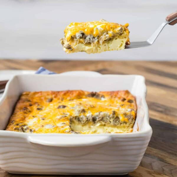 9x13 pan of breakfast casserole made with crescent rolls, one slice being lifted from the pan on a spatula.