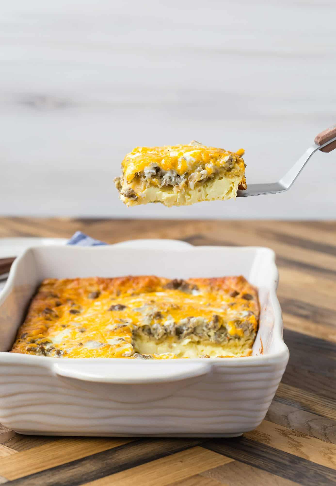 9x13 pan of breakfast casserole made with crescent rolls, one slice being lifted from the pan on a spatula.