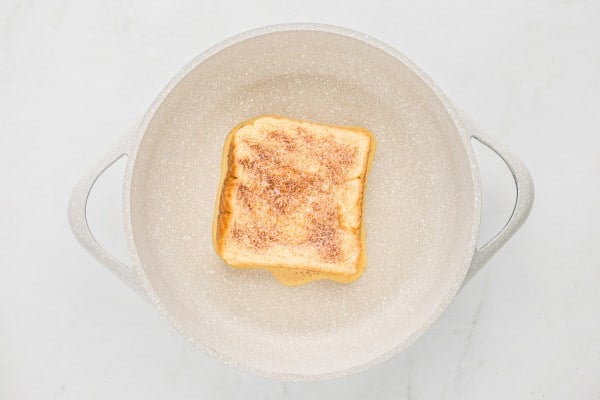 French toast, partially cooked, in a frying pan.