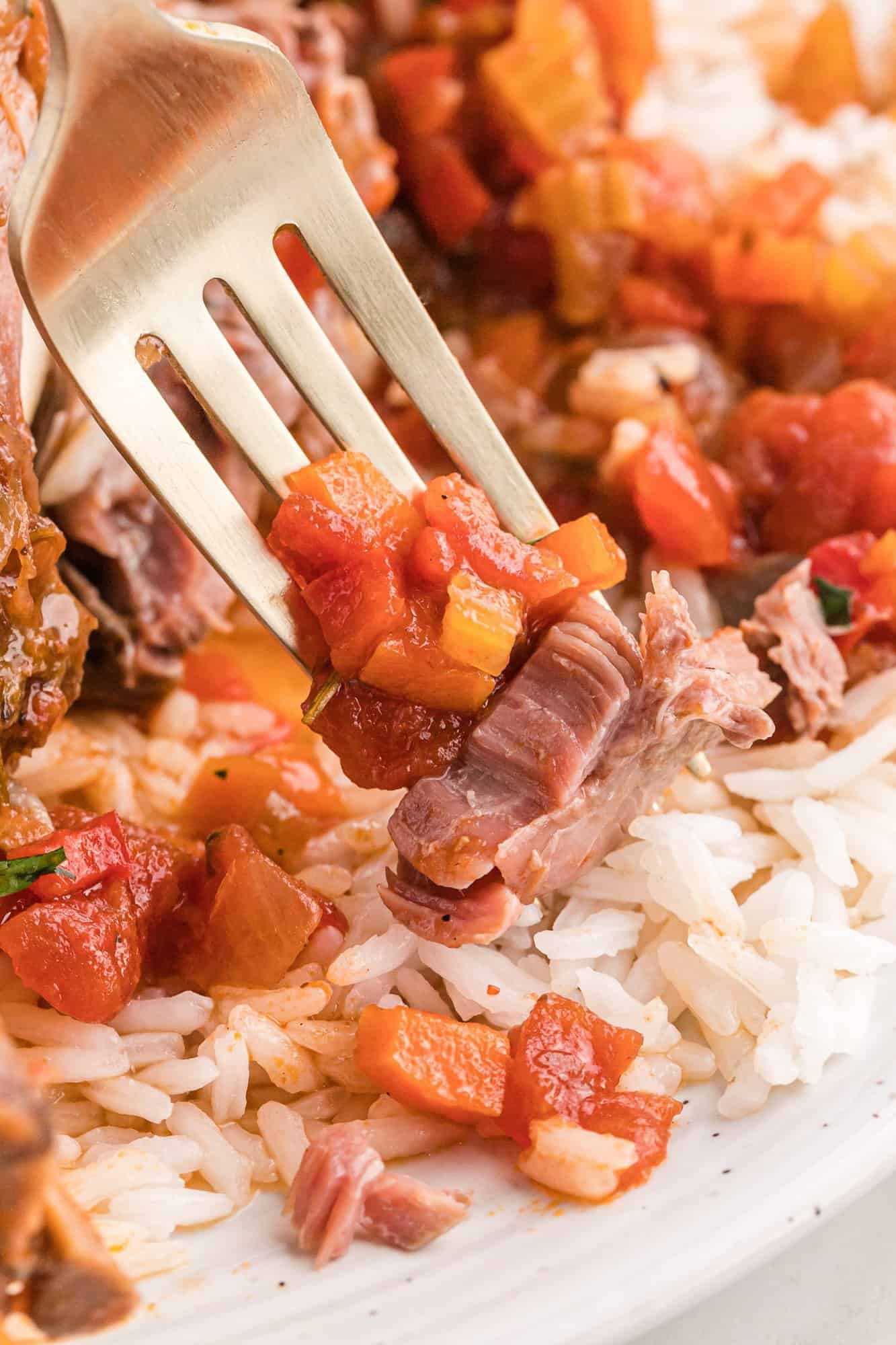 Lamb and vegetables on a fork.