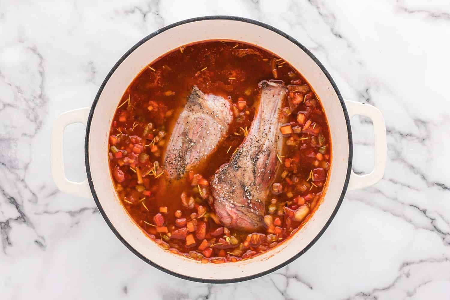 Uncooked lamb in braising liquid.