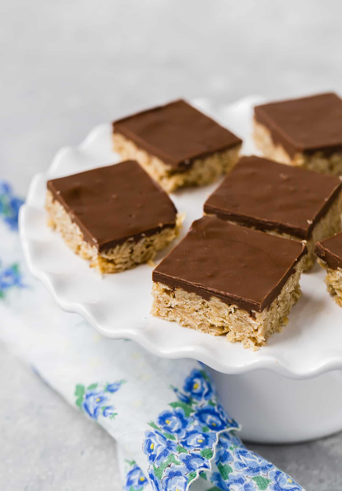 Oat and chocolate bars on a white cake stand.